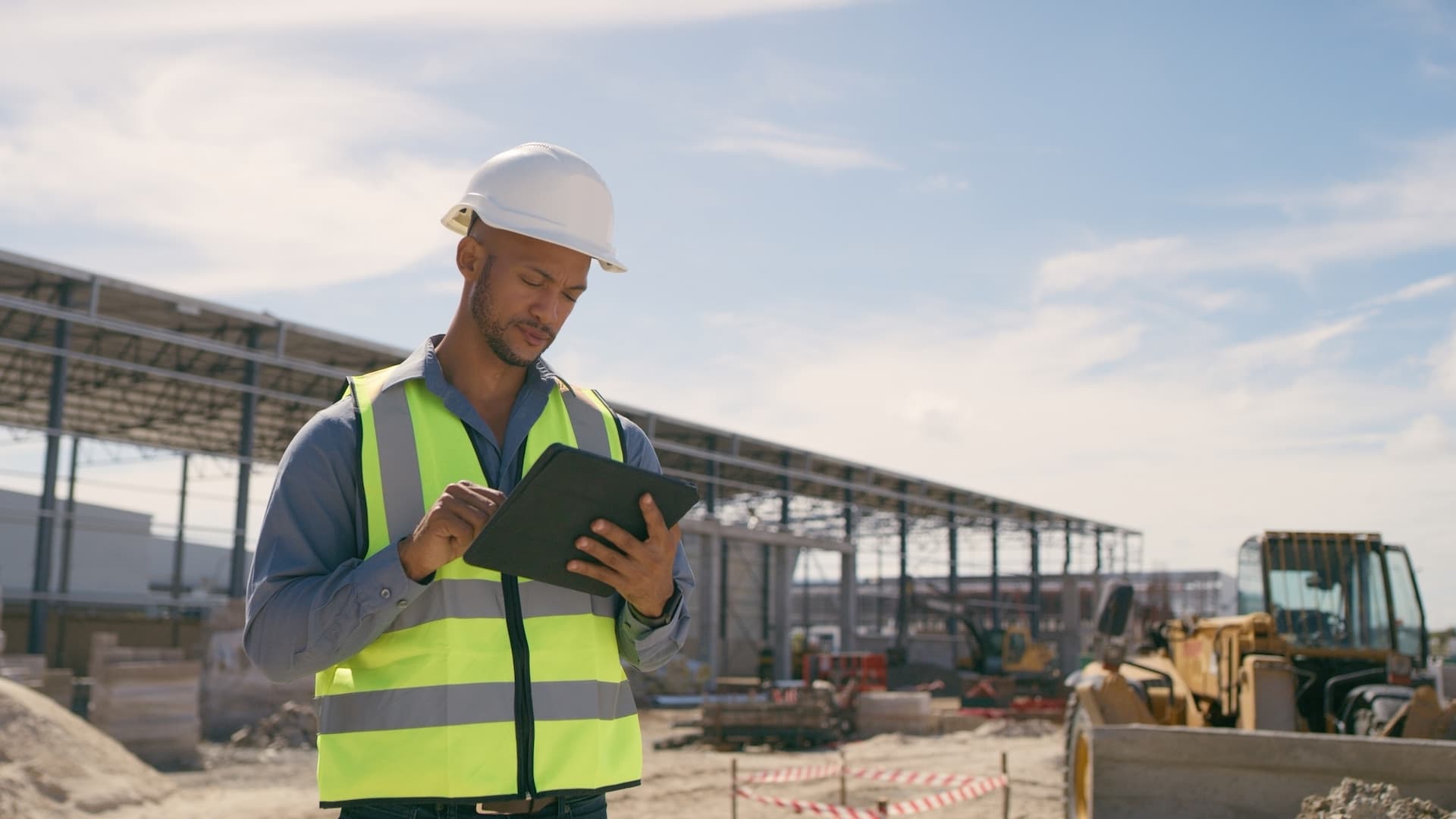 Professional with tablet on active construction site